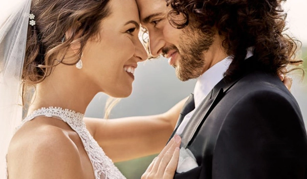 Close-up of a happy bride and groom smiling together, representing wedding photo retouching and editing services