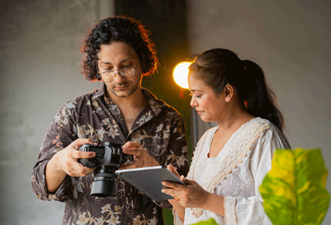 Professional photographer reviewing photo editing preferences on a tablet with digital retoucher